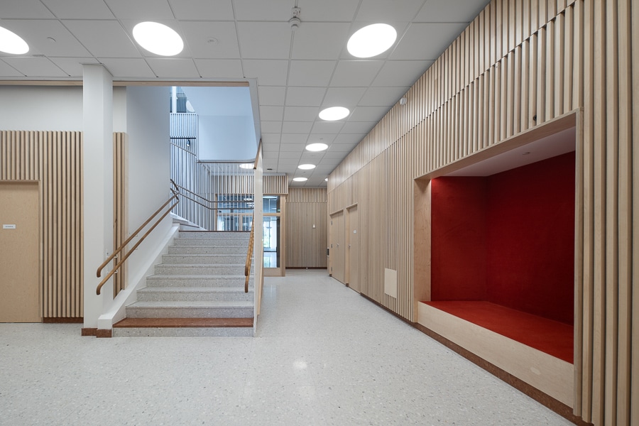 Eleonoraskolan - tegelkvalité. 4 Ett trapphus med sittyta inbyggd i väggen. Väggarna klädda med blont tr'.