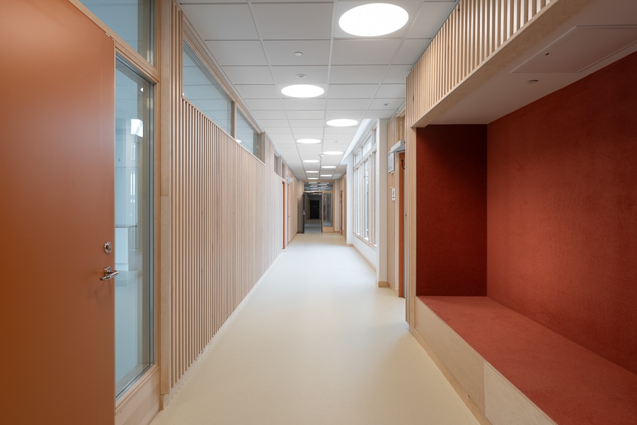 Eleonoraskolan - tegelkvalité. 7 Eleonoraskolan i Botkyrka kommun. Byggare är Arcona, arkitekt är Arkitema. En korridor med infälld sittyta.