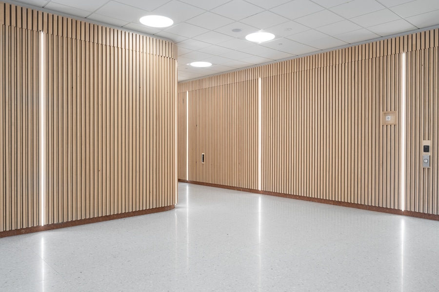 Eleonoraskolan - tegelkvalité. 10 Korridor i Eleonoraskolan, Hallunda utanför Stockholm. Eleonoraskolan i Botkyrka kommun. Byggare är Arcona, arkitekt är Arkitema. Exempel på belysning infälld i de träbeklädda väggarna.