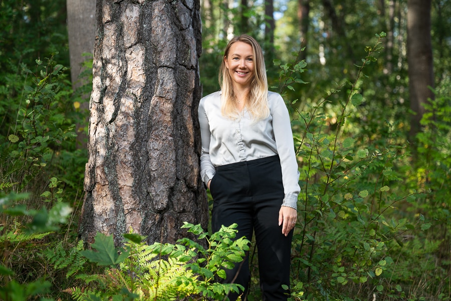 Vanliga frågor om företagsporträtt 4 Företagsporträtt av Paulina, hållbarhetsansvarig på IT-Total i Solna. Fotograferad i en skogsdunge, modellen lutar sig mot en trädstam.